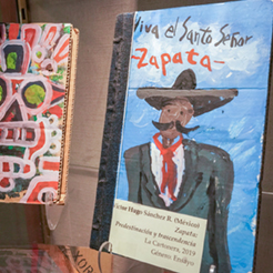 A book with a handpainted cover that says the word "Zapata"is on display